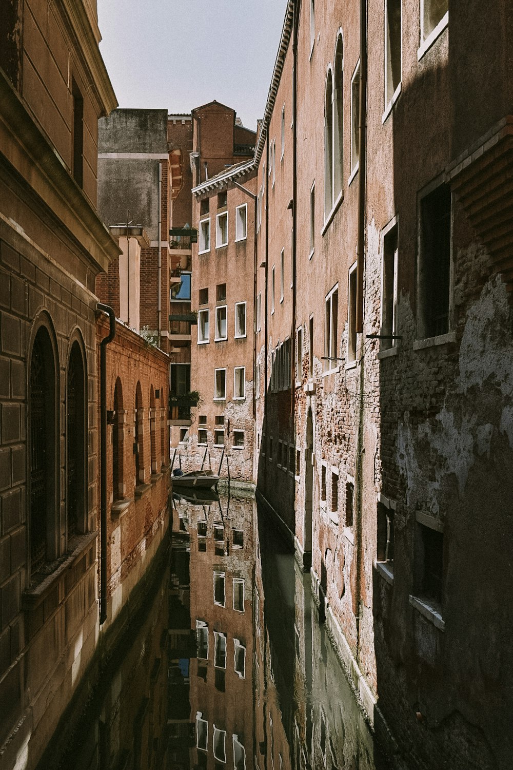a narrow canal in a city with buildings on either side