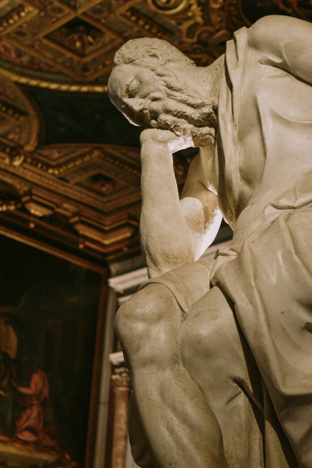 a statue of a man holding his head in his hands