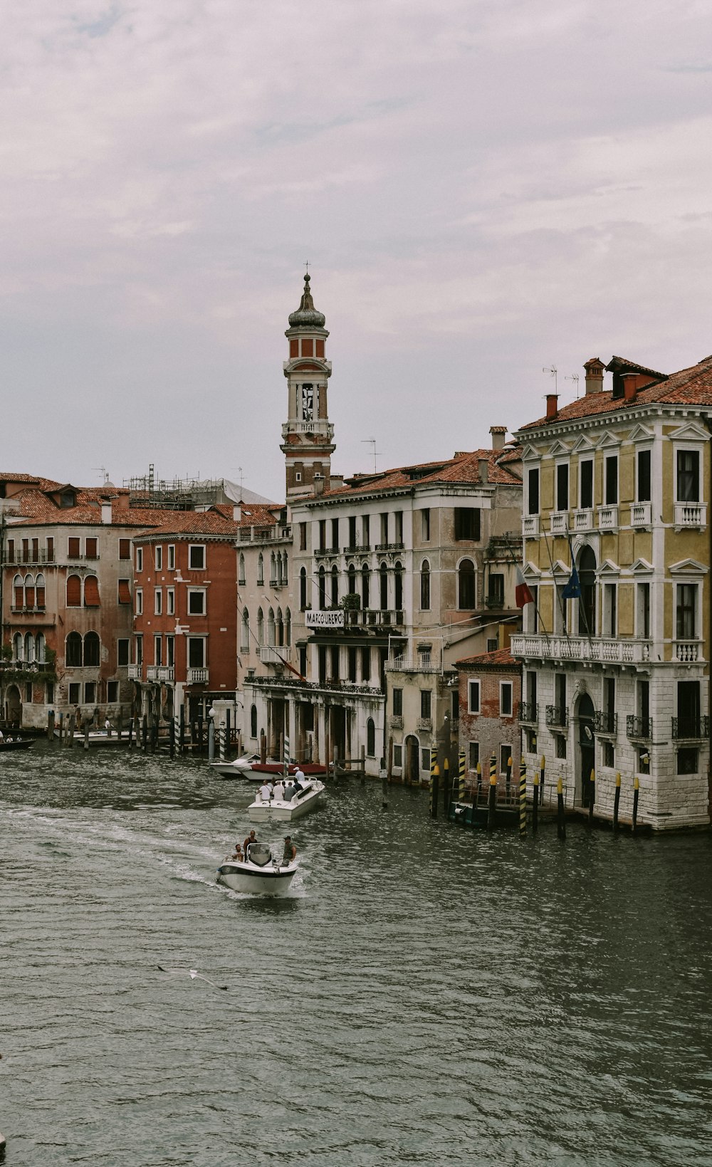 a boat traveling down a river next to tall buildings