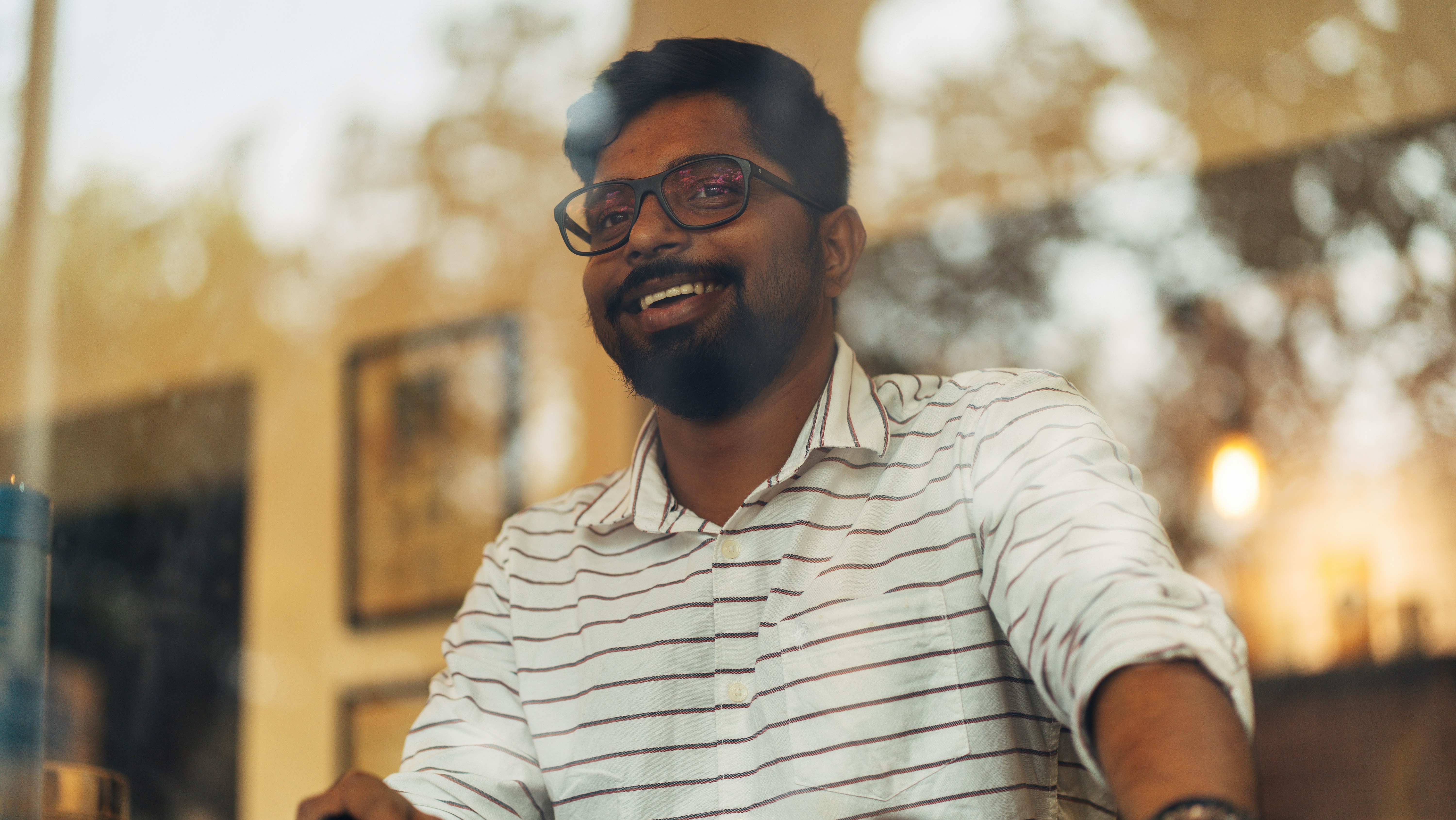 a man with a beard and glasses sitting at a table