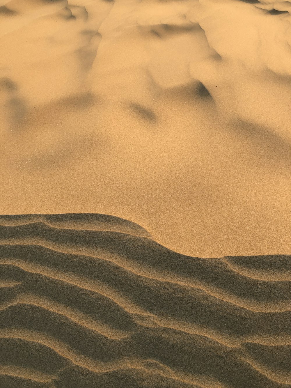 a desert landscape with sand dunes and mountains in the distance