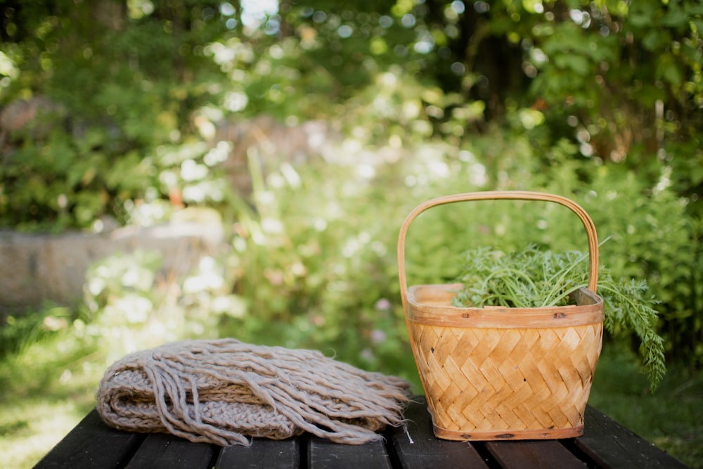 a basket and a blanket on a picnic table