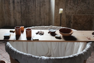 A rustic wooden table showcasing an assortment of artisanal candles and soaps.