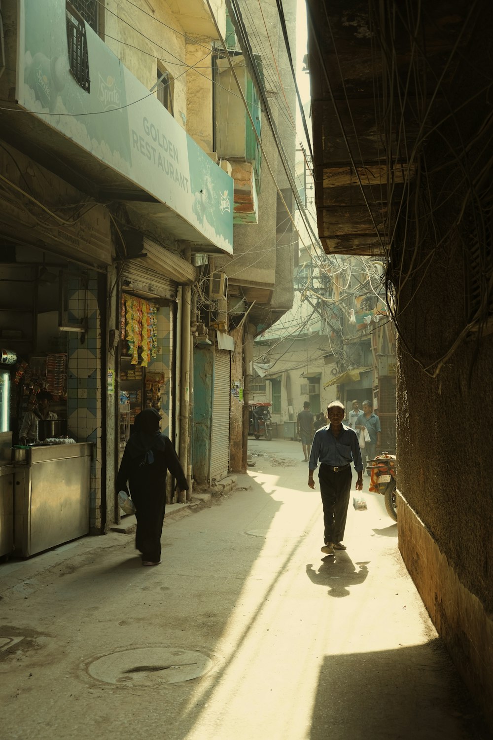 a man walking down a street next to a tall building