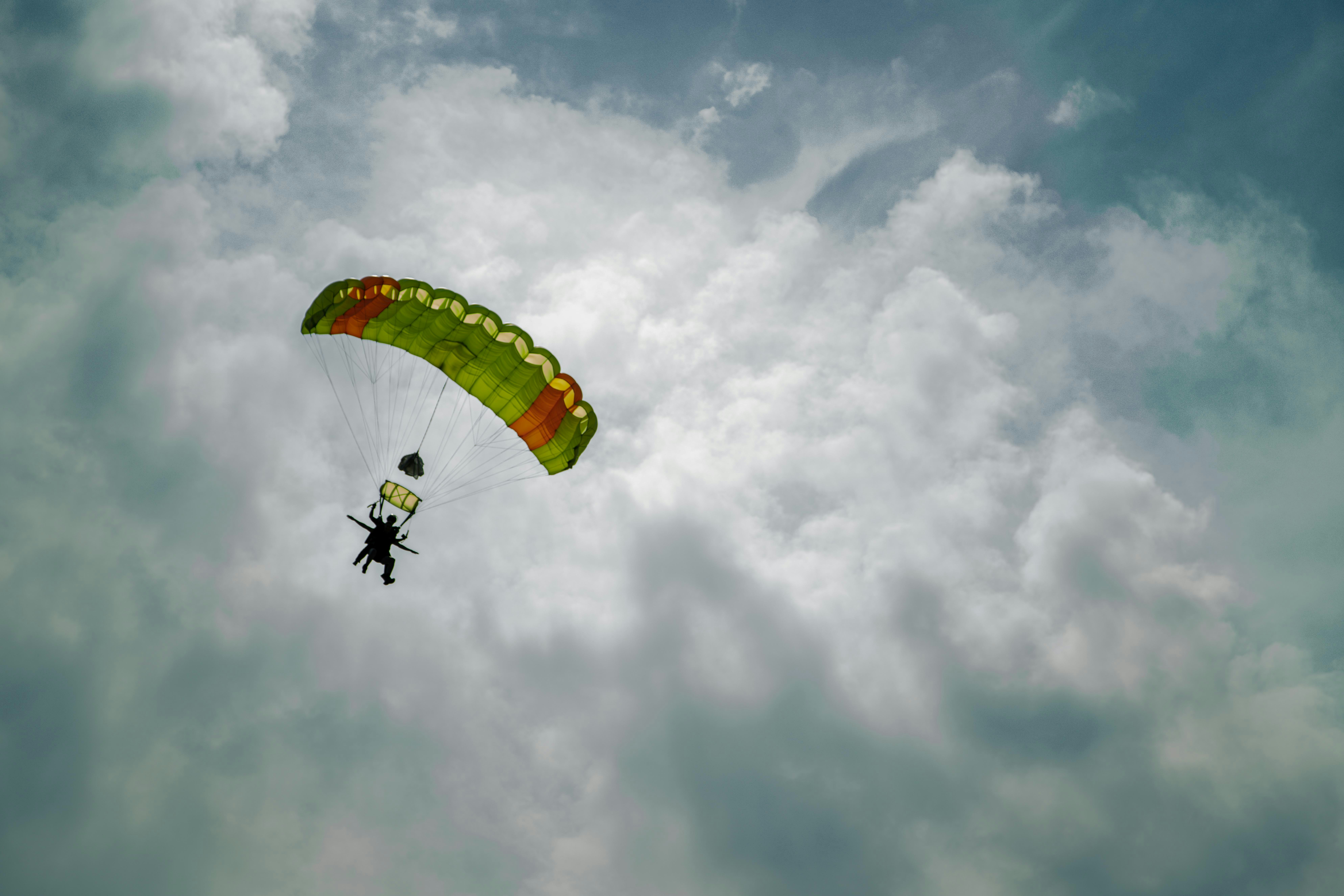 a person is parasailing in the sky on a cloudy day