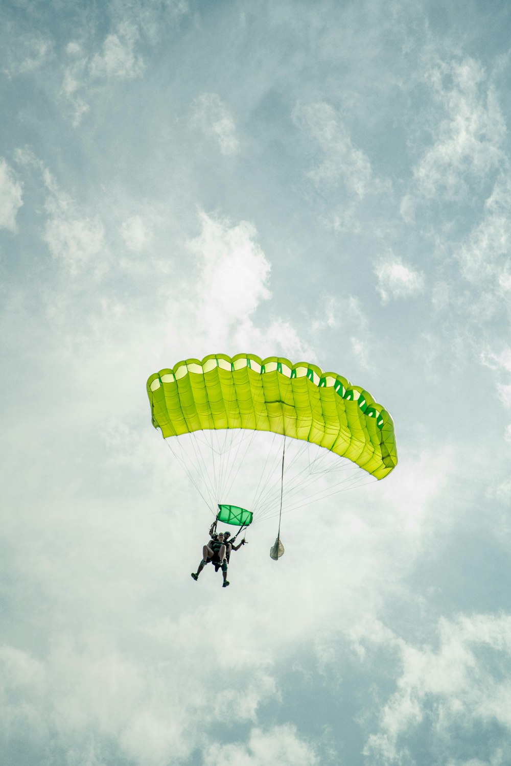 a person is parasailing in the air on a cloudy day