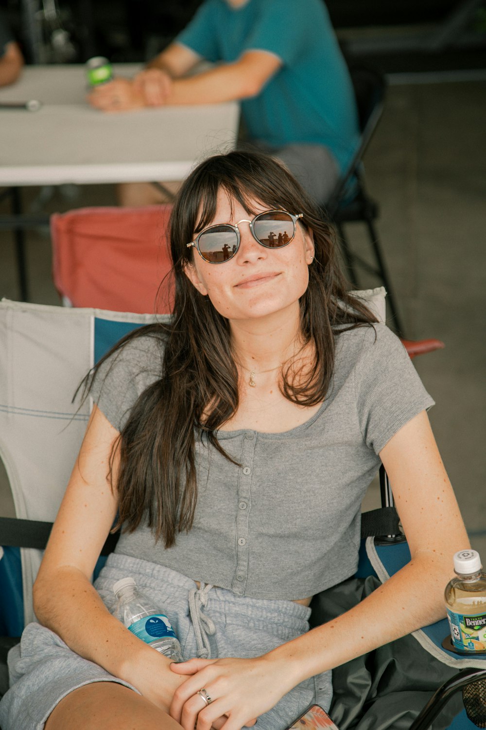 a woman sitting in a chair wearing sunglasses