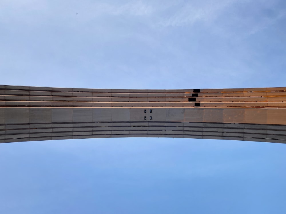 the underside of a bridge against a blue sky