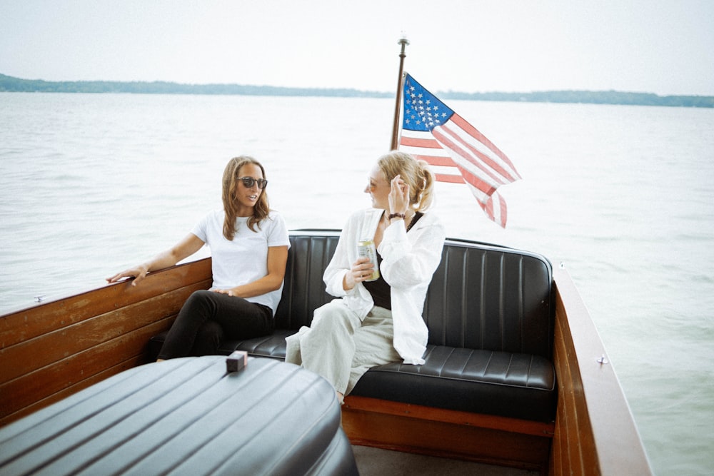 two women sitting on a boat in the water