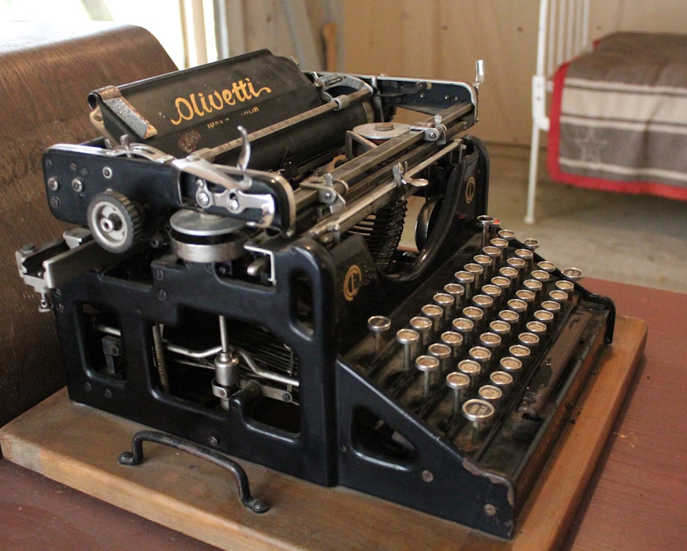 an old fashioned typewriter sitting on top of a wooden table