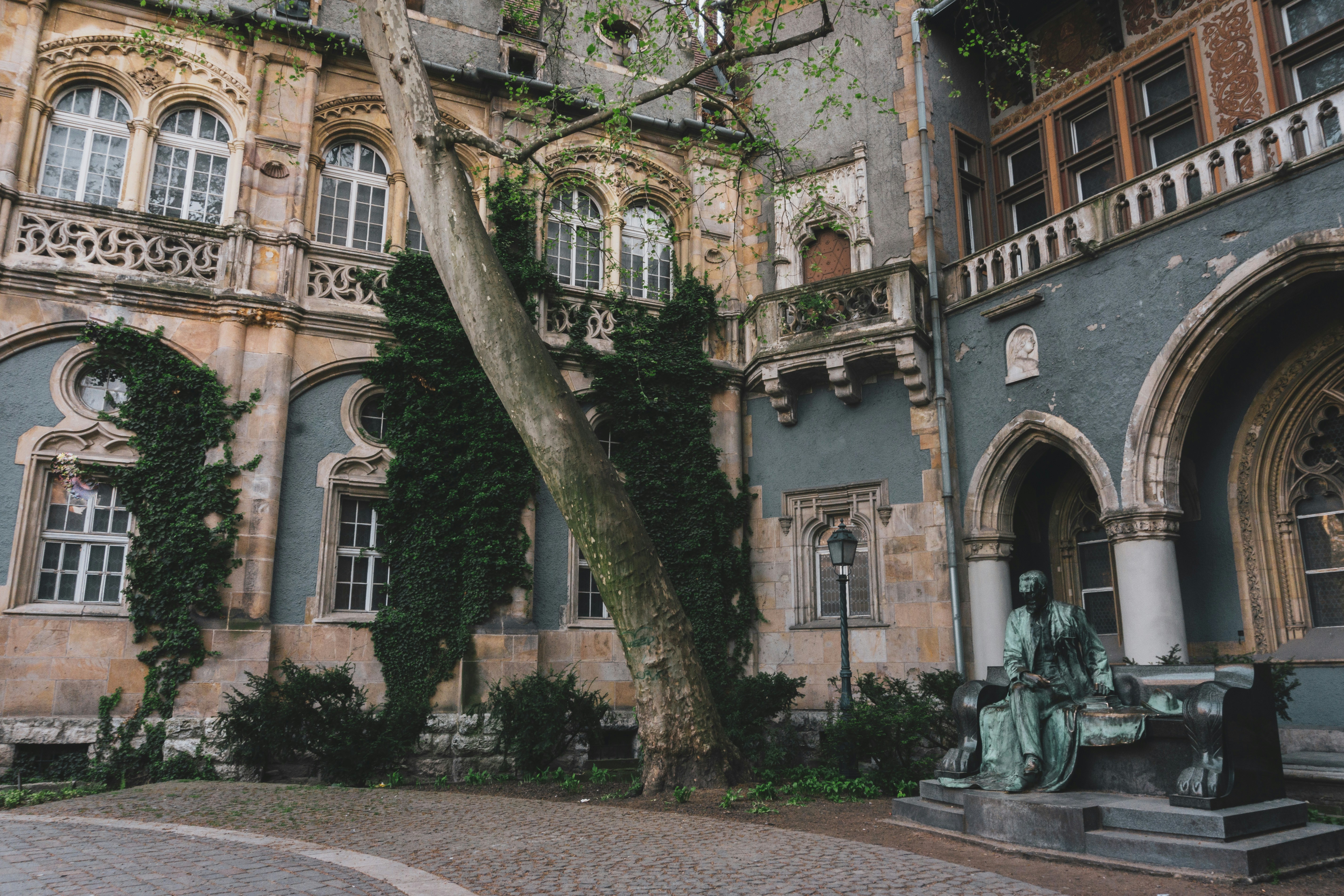 an old building with a statue in front of it, 