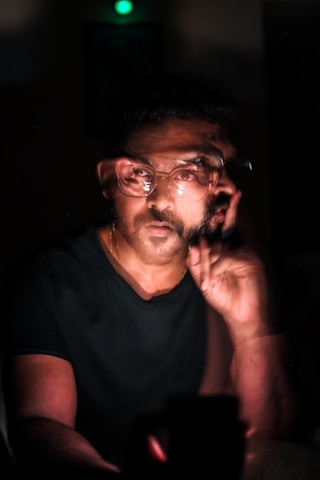 a man with glasses talking on a cell phone
