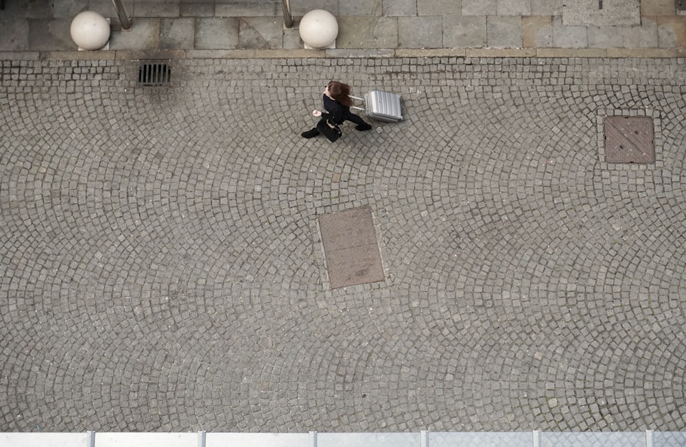 uma pessoa sentada em um banco em uma rua de paralelepípedos