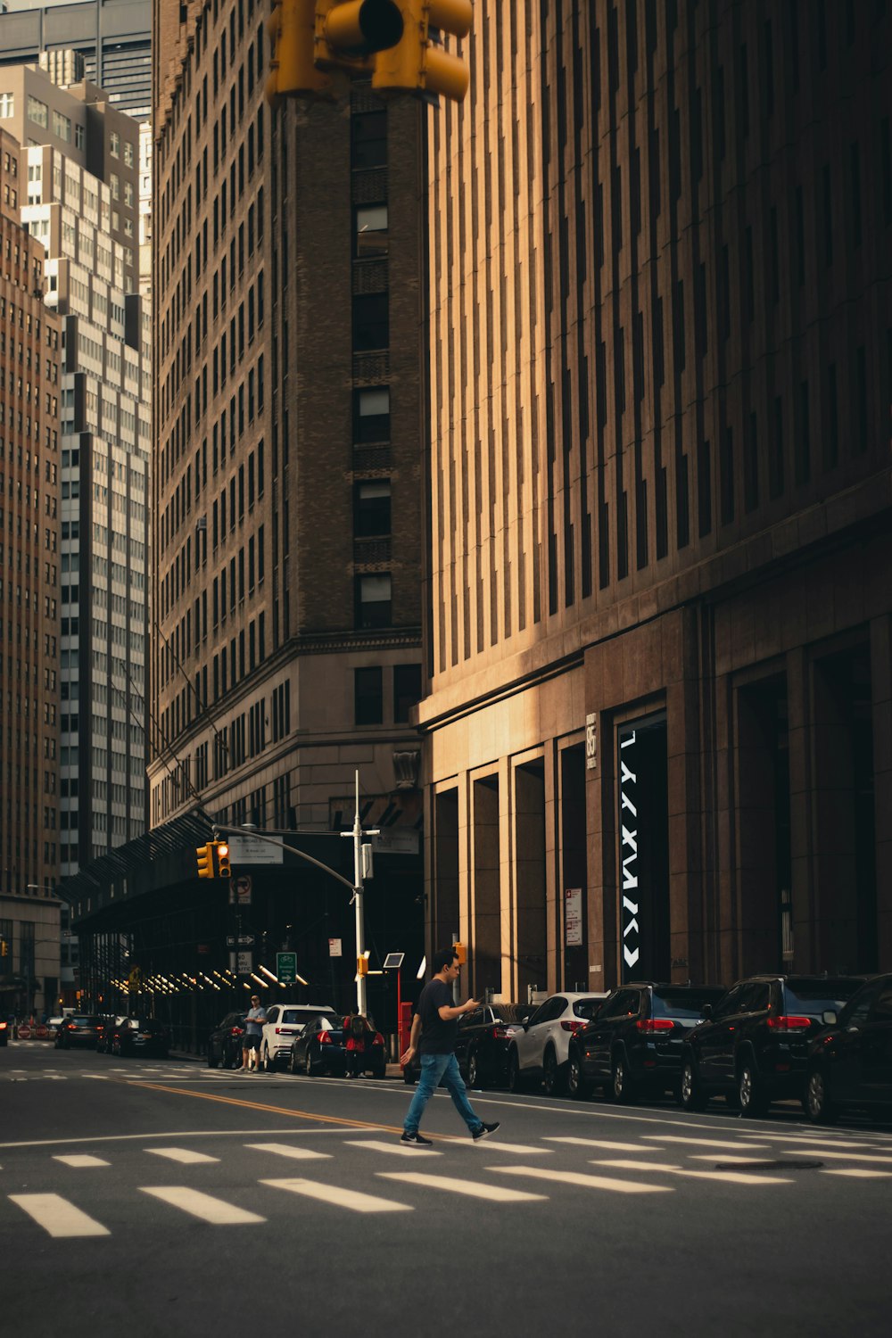 a person crossing a street in front of tall buildings