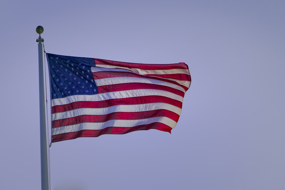 a large american flag flying in the wind