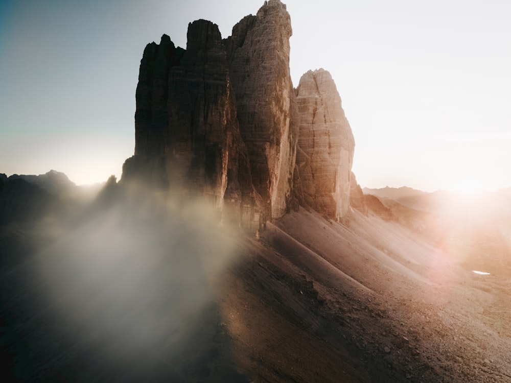 the sun shines through the fog in the mountains