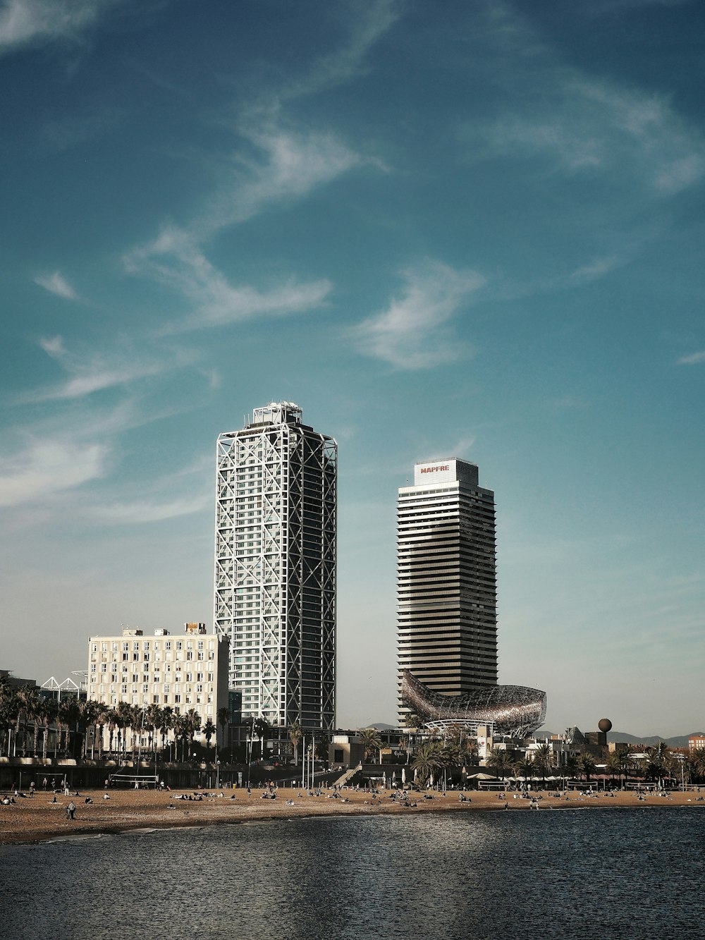 a couple of tall buildings next to a body of water