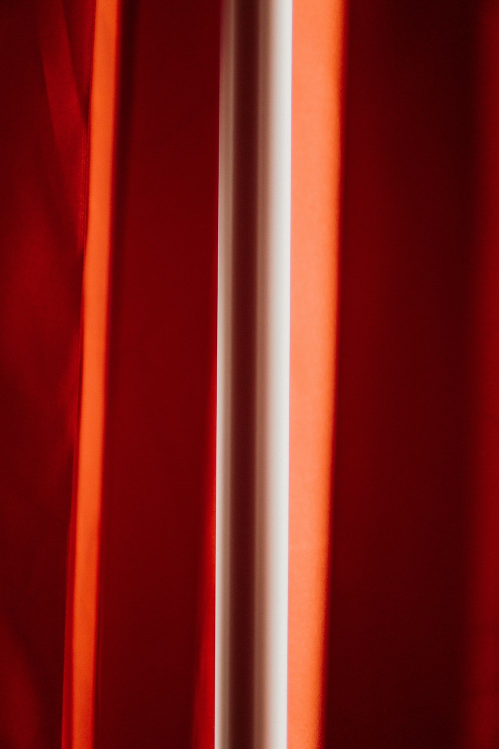 a red curtain with a white pole sticking out of it