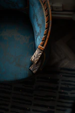 a blue chair with a wooden arm rest
