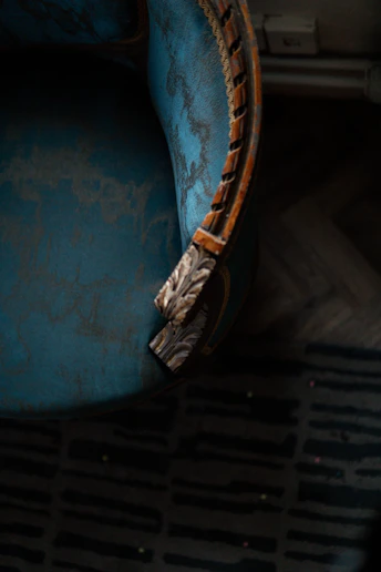a blue chair with a wooden arm rest