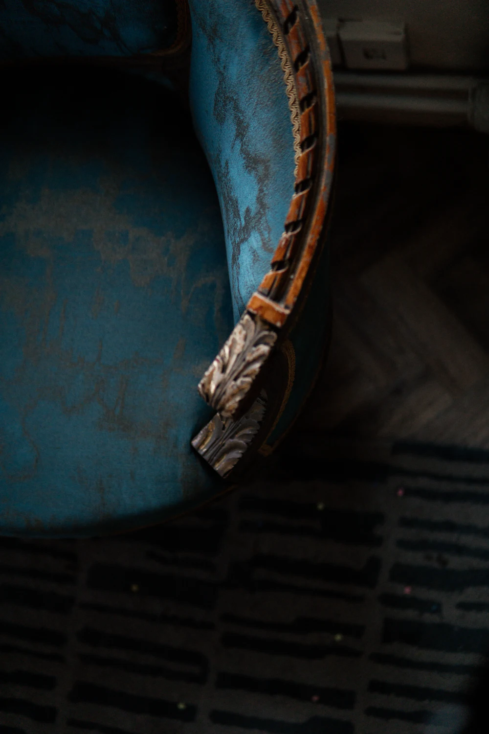 A blue chair with a timber arm rest