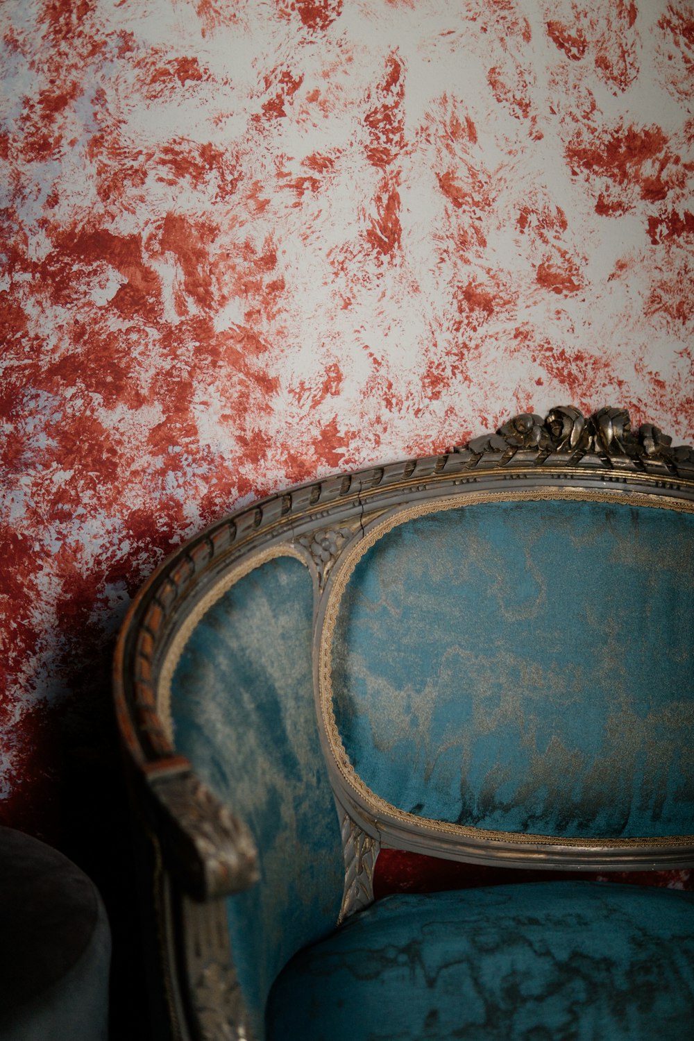 a blue chair sitting in front of a red wall