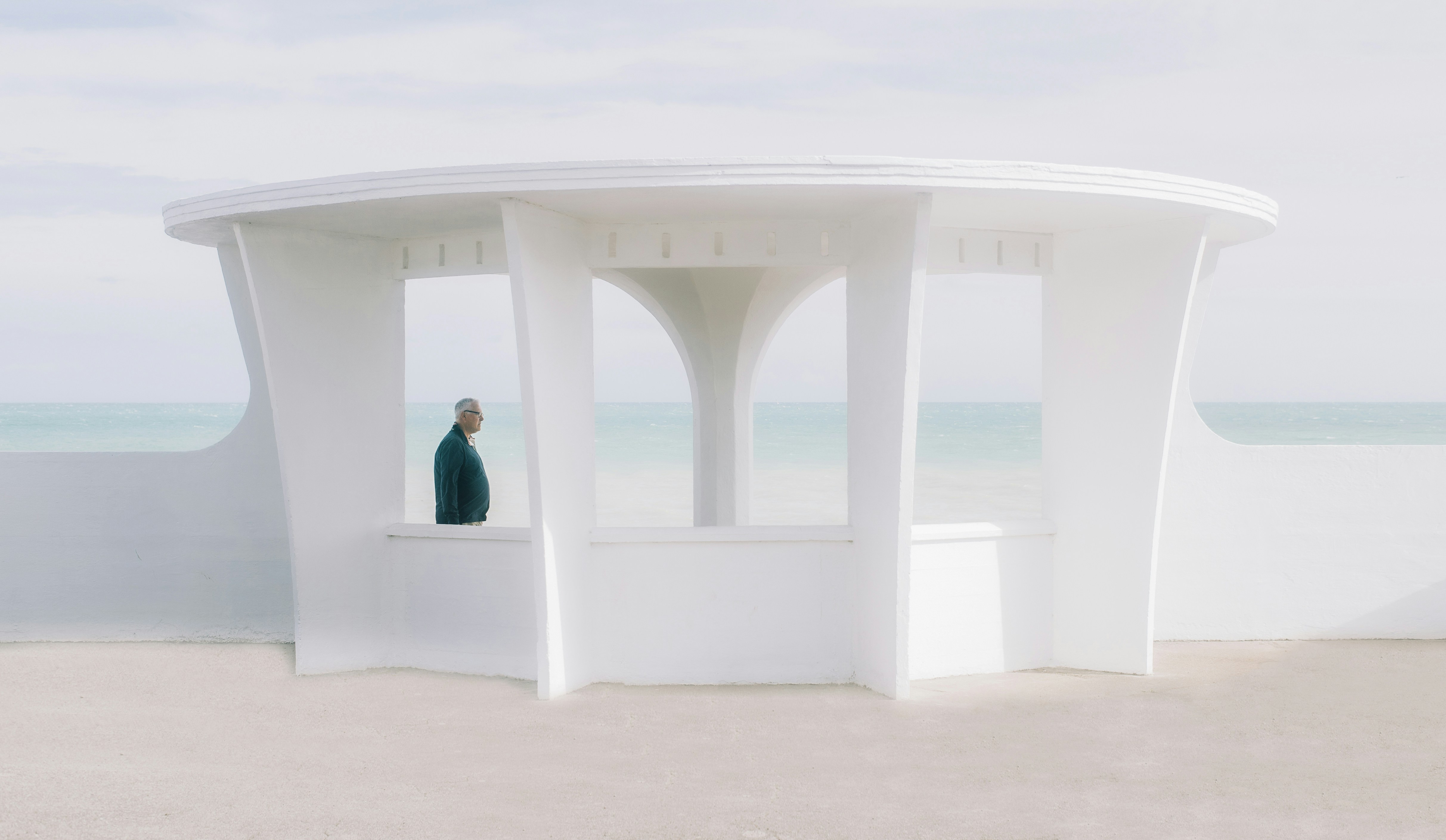 a person standing in a white structure on the beach