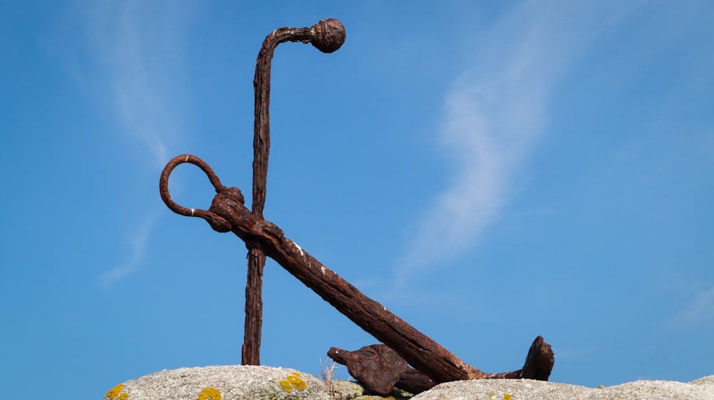 a rusty anchor sitting on top of a rock
