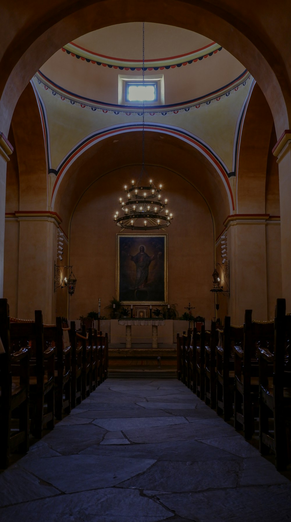 a dimly lit church with a painting on the wall