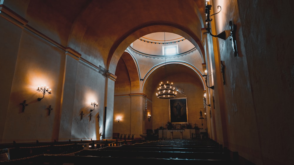 the interior of a church with pews and chandeliers