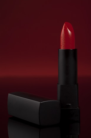 Close-up of a vibrant lipstick shade from 4a's cosmetics, resting on a textured fabric.