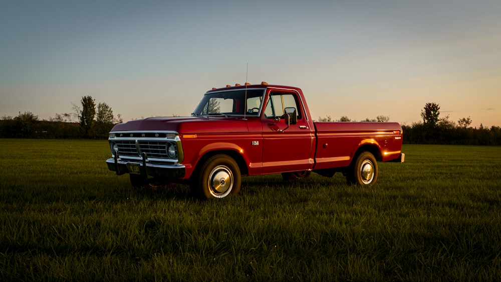 a red truck is parked in a field