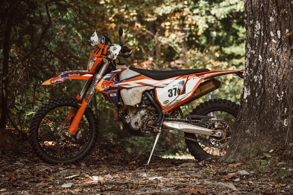 a dirt bike parked next to a tree