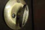 Close-up of a golden lock being expertly installed on a sleek black door.
