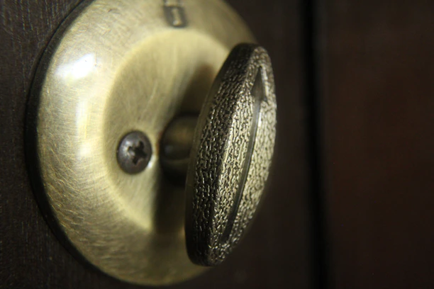 Close-up of a luxury door lock with polished chrome and warm light reflections