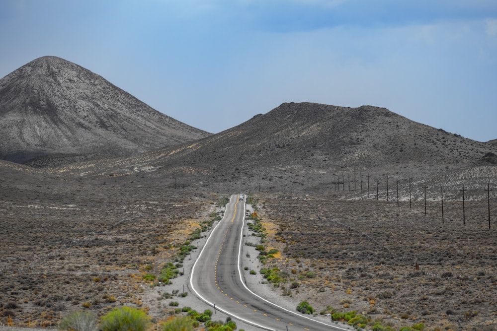 a road in the middle of a desert with mountains in the background