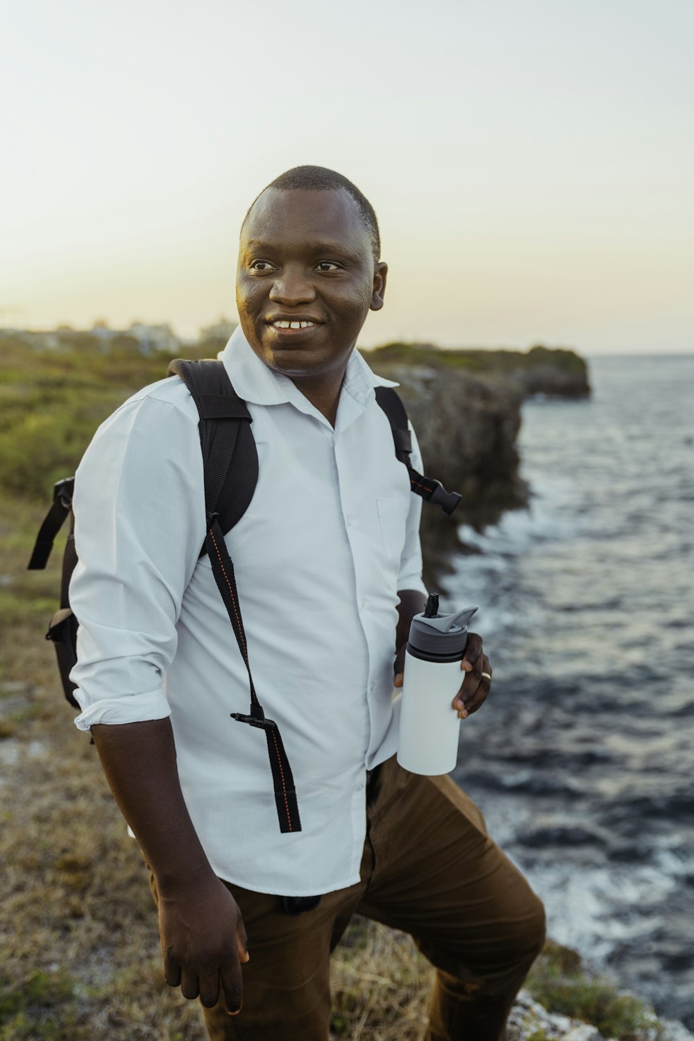 a man with a backpack and a cup of coffee