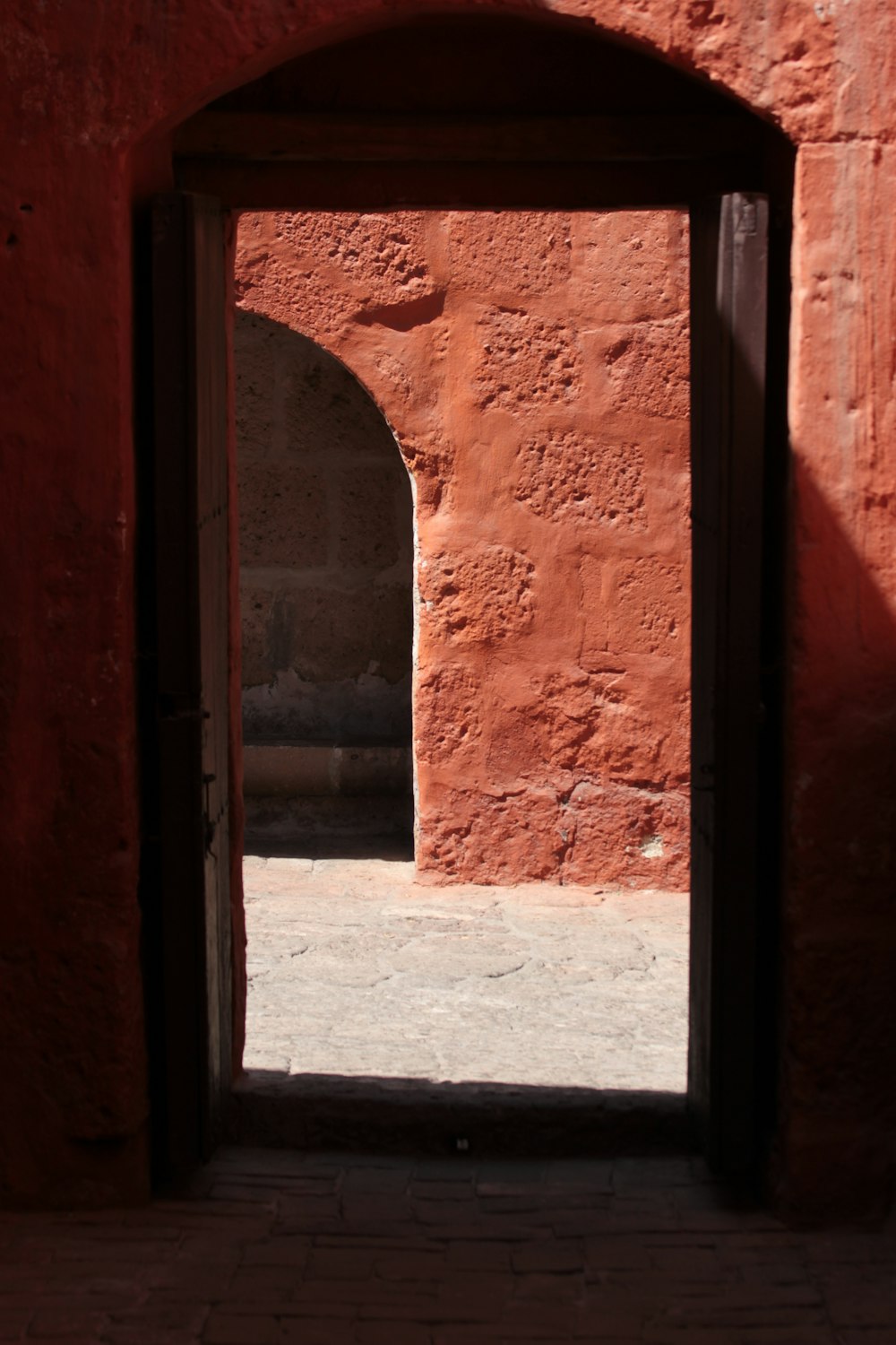 Una puerta abierta en una pared de ladrillo rojo