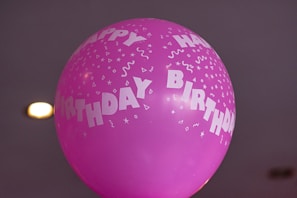 A vibrant birthday celebration on a boat with colorful balloons and a cake.