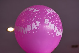 A vibrant birthday celebration on a boat with colorful balloons and a cake.
