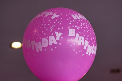 A colorful birthday card featuring balloons and confetti with a blank inside page.