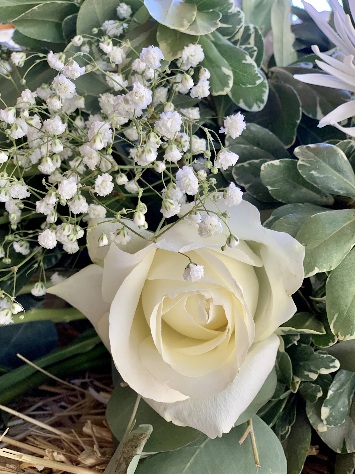 A close-up of a beautifully arranged bouquet featuring fresh seasonal flowers with soft green and cream accents.