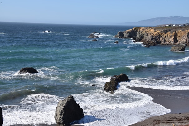 Scenic rocky coastline with clear blue ocean waves.