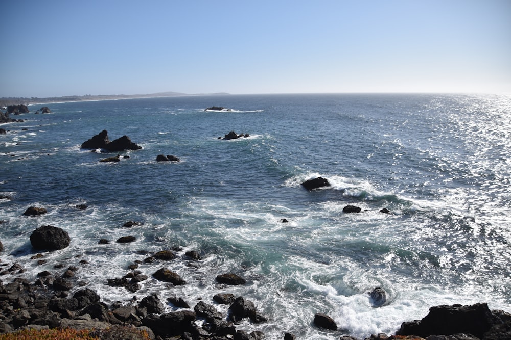 a view of a body of water with rocks in the foreground