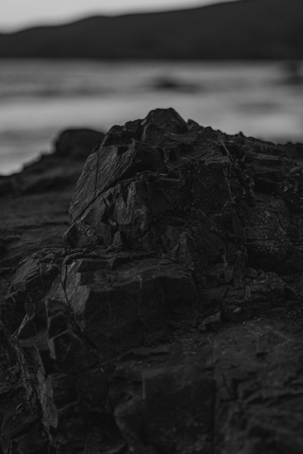 a black and white photo of rocks on the beach