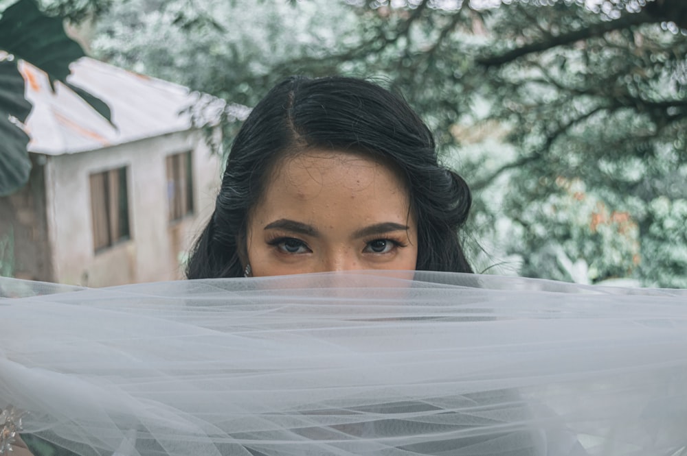 a woman holding a veil over her face