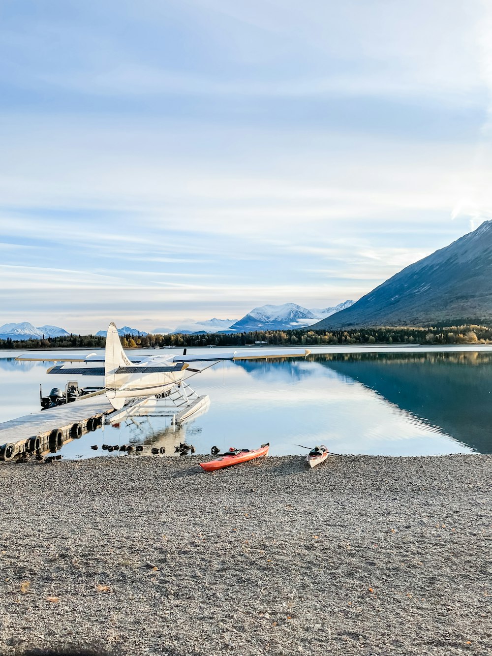 a small plane sitting on the shore of a lake