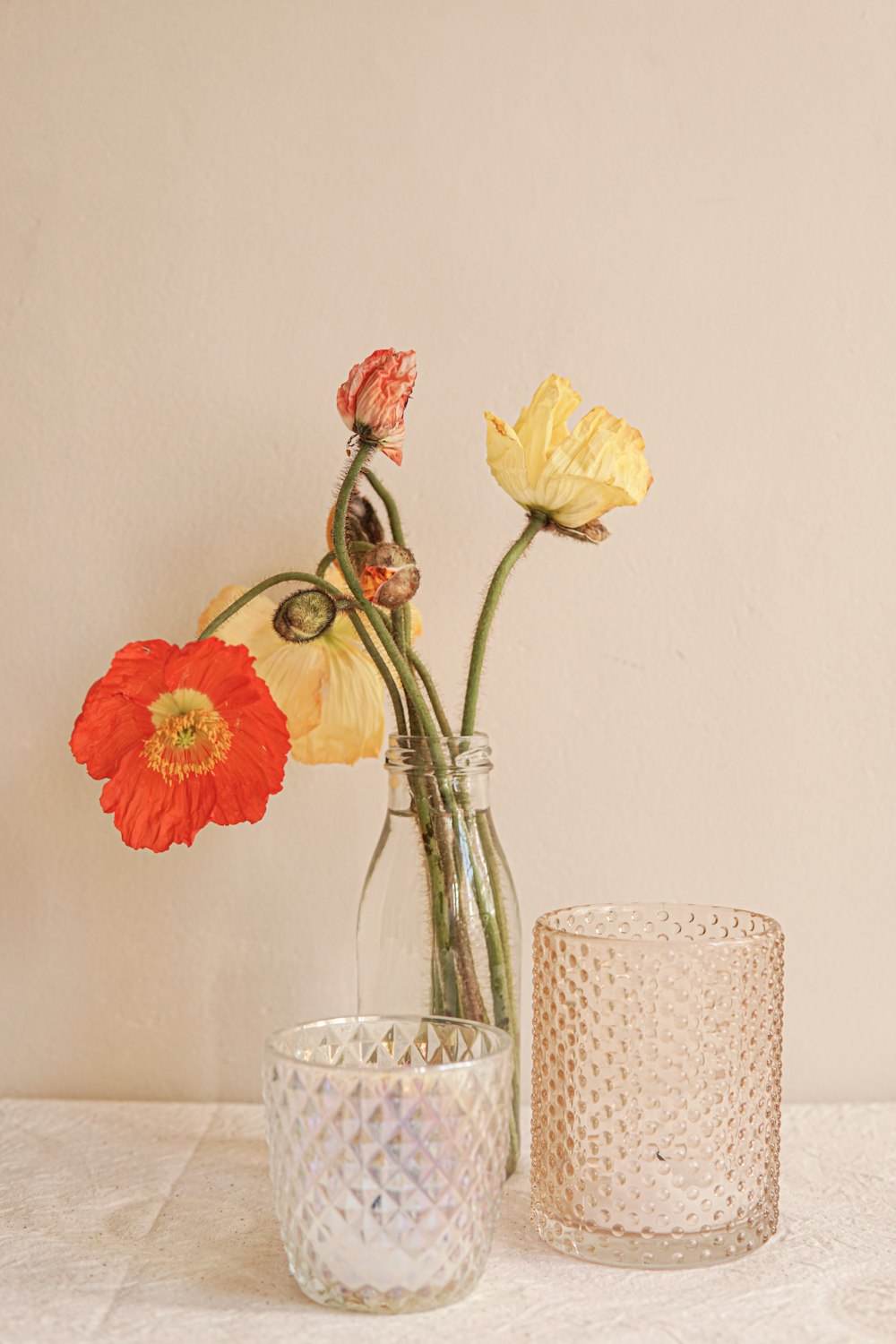 two vases with flowers in them sitting on a table