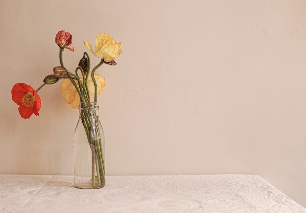 a vase filled with yellow and red flowers