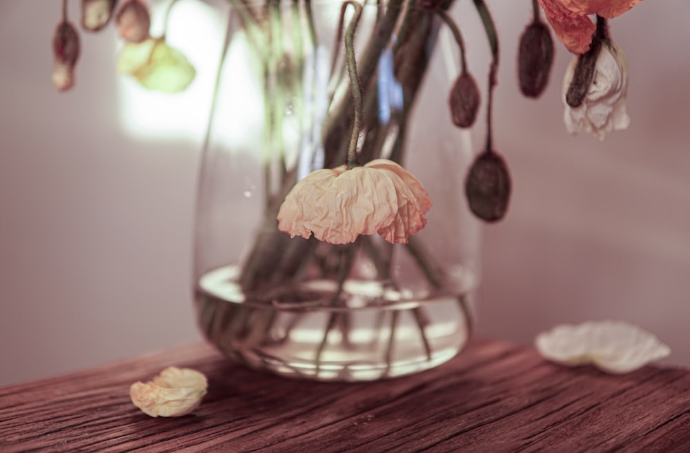 un vase rempli de fleurs sur une table en bois